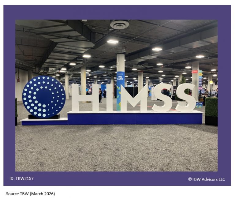 BIg blue round circle with three inner circle of dots. to the left of HUGE H I M S S letters - life size letters. An obvious place people take pictures for social media. Exhibits and attendees seen in the distant background.