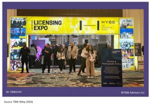 Bright yellow Licensing Expo neon sign framing entrance with lots of people in the doorway.