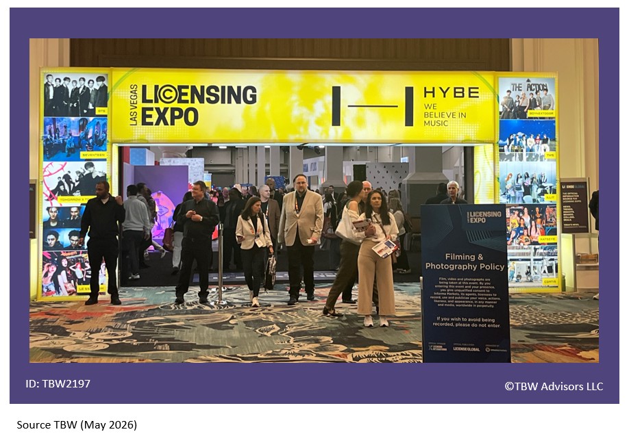 Bright yellow Licensing Expo neon sign framing entrance with lots of people in the doorway.