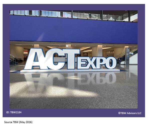 ACT Expo white sign outlines in blue with a cool matching blue on the LVCC digital sign behind it. Image taken in West LVCC lobby. The marble floors in foreground can be seen.