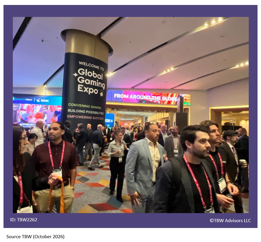 Crowds walking toward you. Huge pillar, wall to ceiling with Global Gaming Expo displayed on wrap. On LED that crowds are walking under it colorfully says from around the globe.